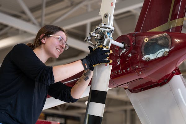 Aviation Programs Girl work on a helicopter tail