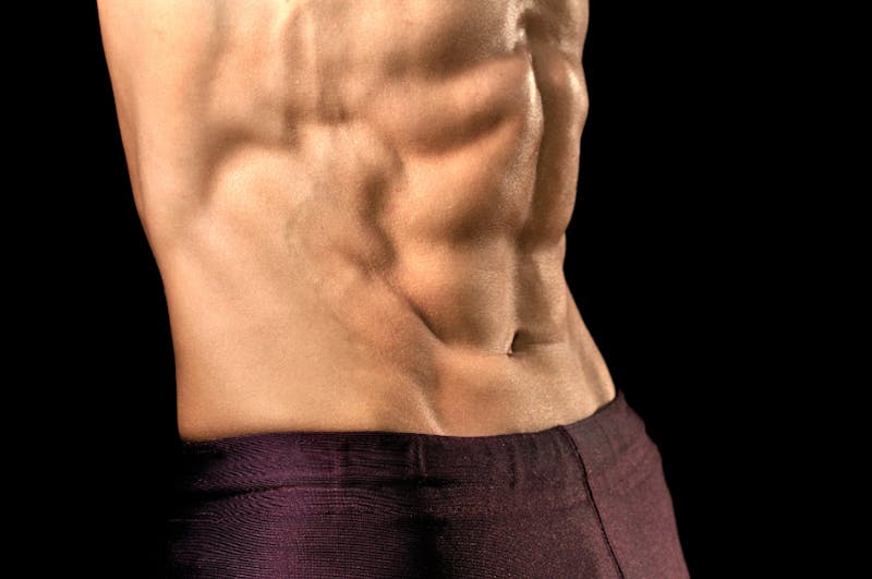 close up of a man's abs with no shirt on posing for a picture