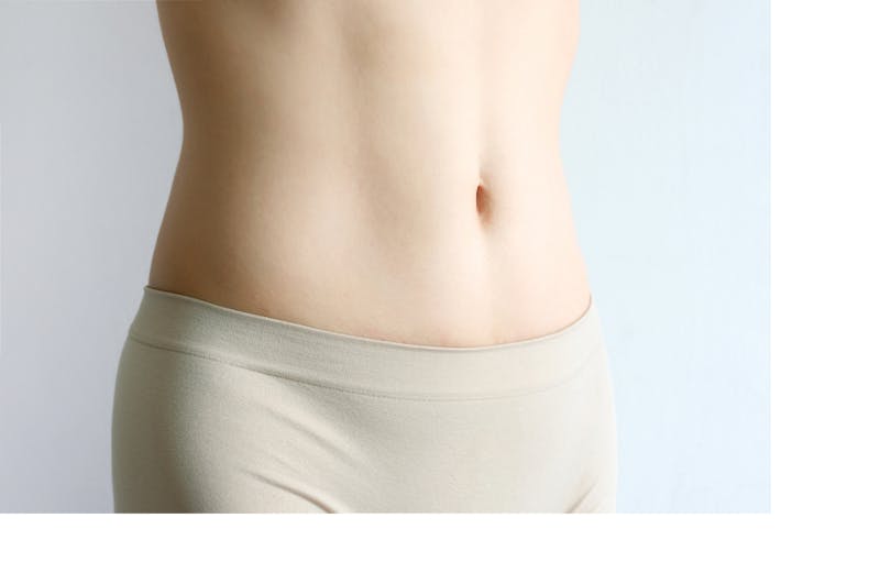 close up of a woman's waist and abs in tan underwear
