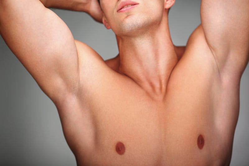 Shirtless man with his arms raised above his head