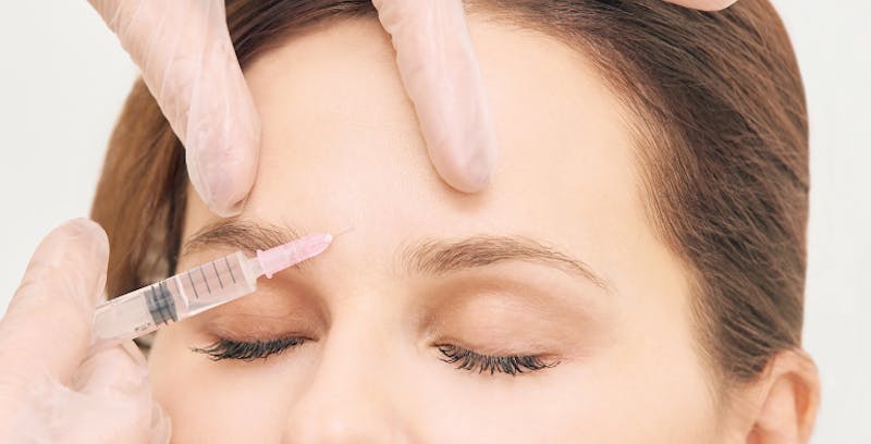 Woman getting injectables in her forehead area