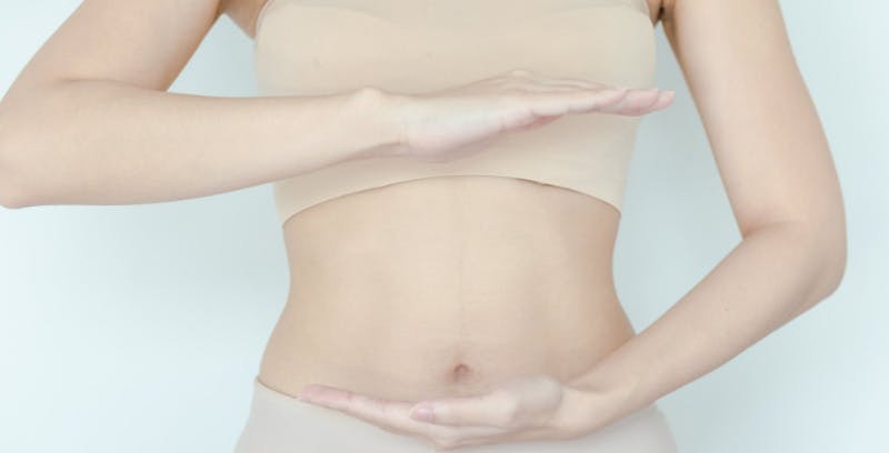 a woman in a bra top holding her hands out in front of her abdomen