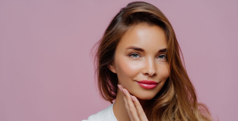woman with long hair and bright pink lipstick posing for a picture