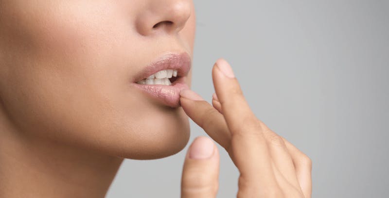 close up of a woman putting her finger on her lips