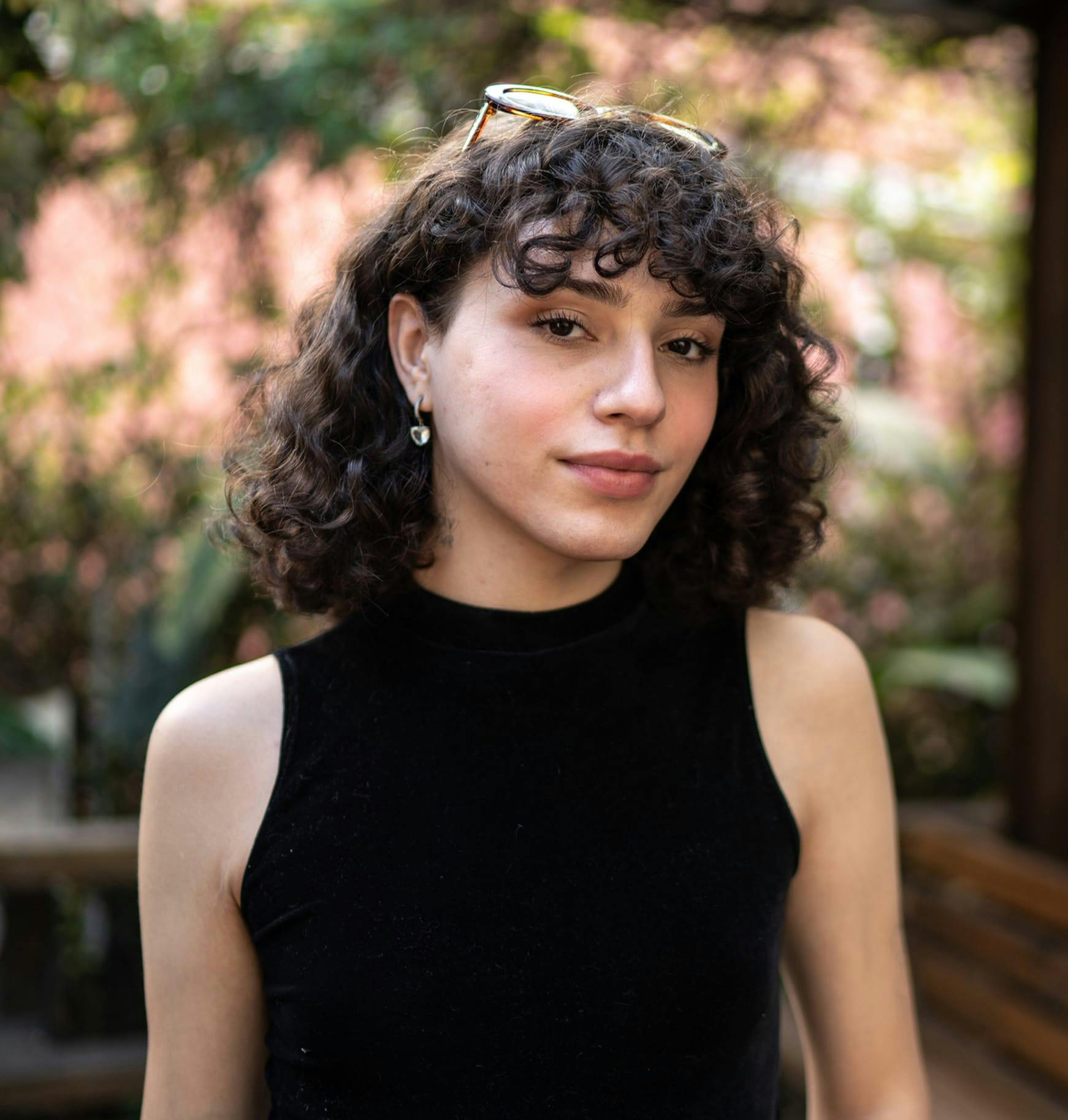 Person with curly hair wearing a black tank top