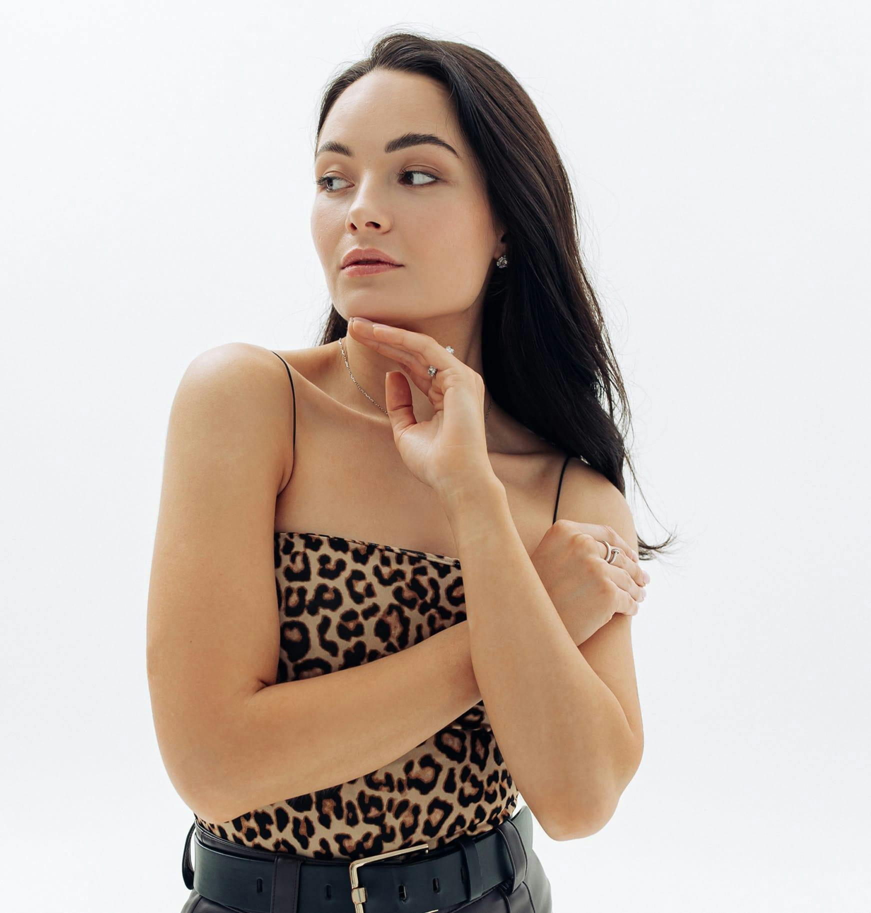 a woman in a leopard print top posing for a picture