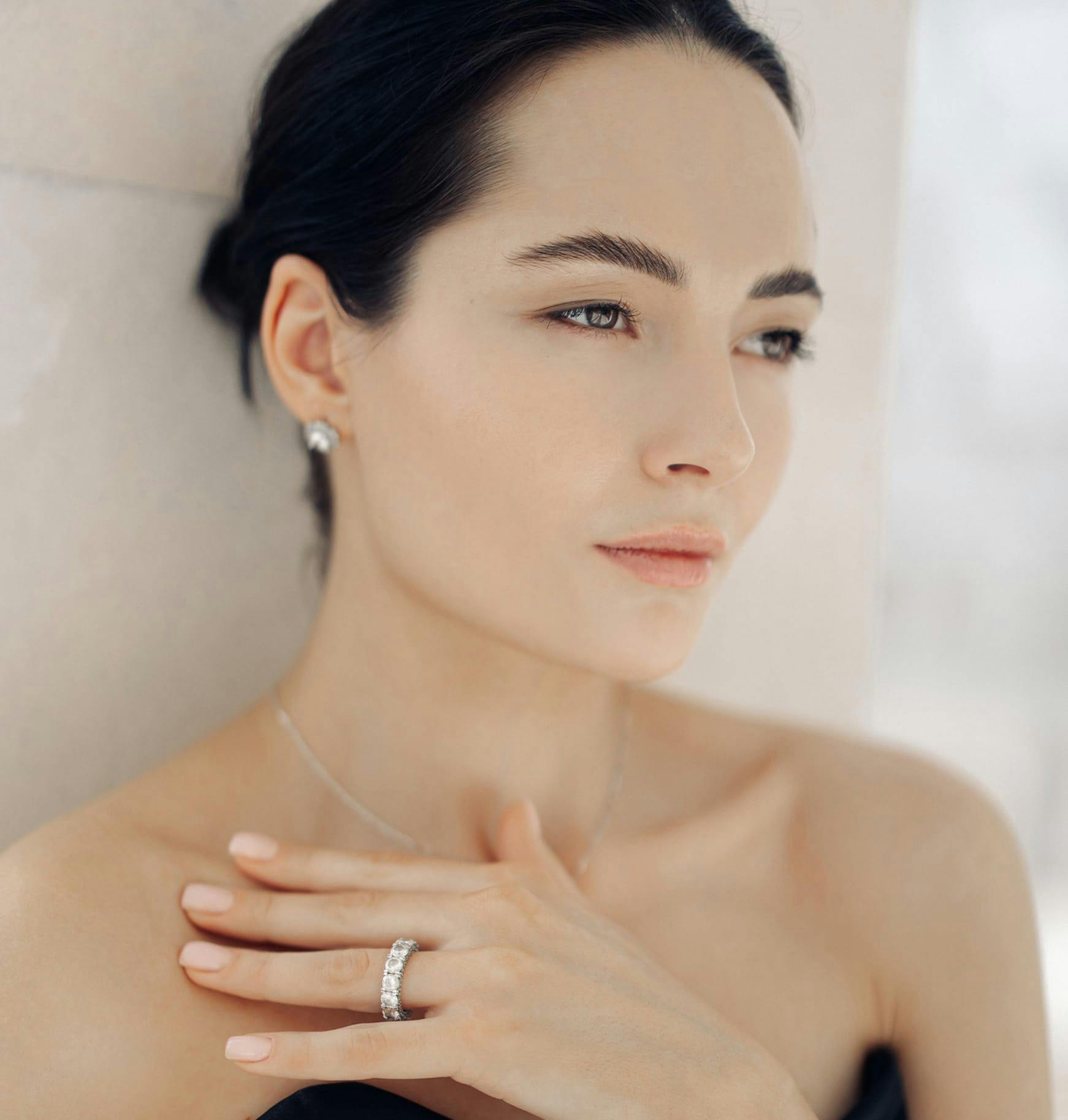 woman with a diamond ring and a diamond necklace posing for camera