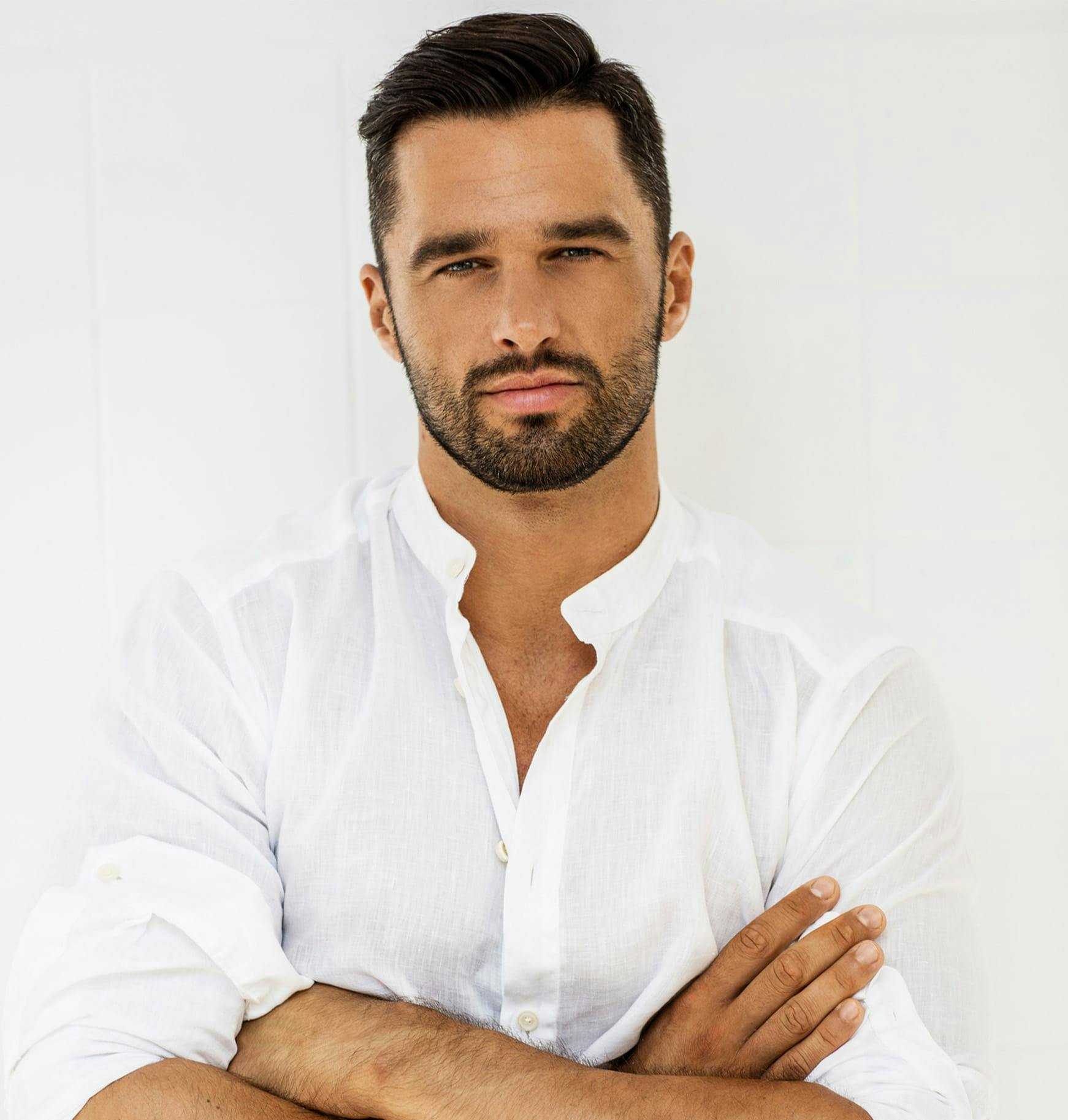 man in a white shirt with his arms crossed