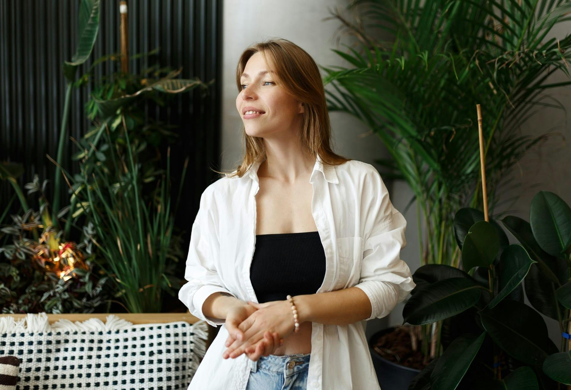 Woman in a white unbuttoned top, black shirt and jeans