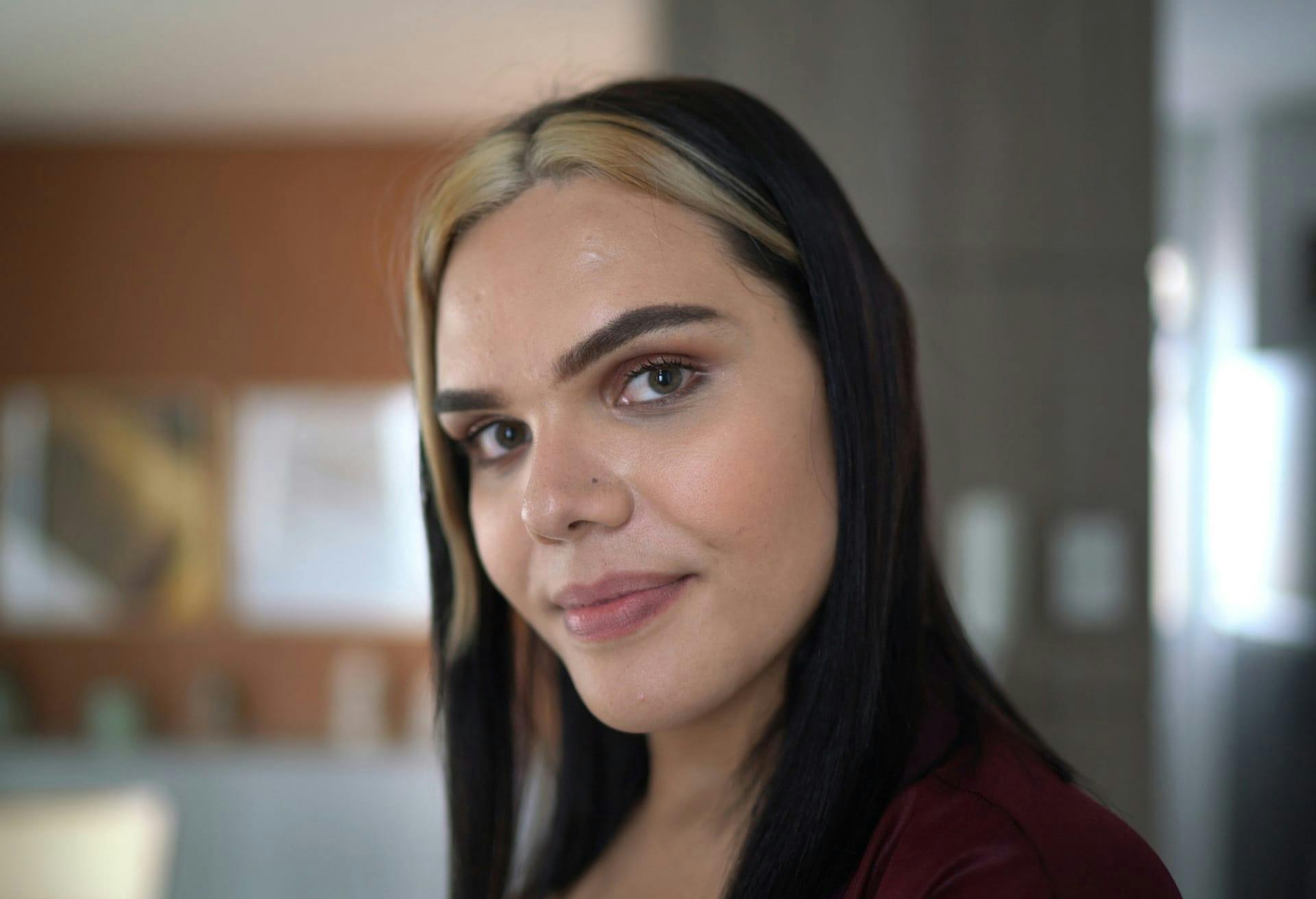 Woman with dark hair and two blonde strips