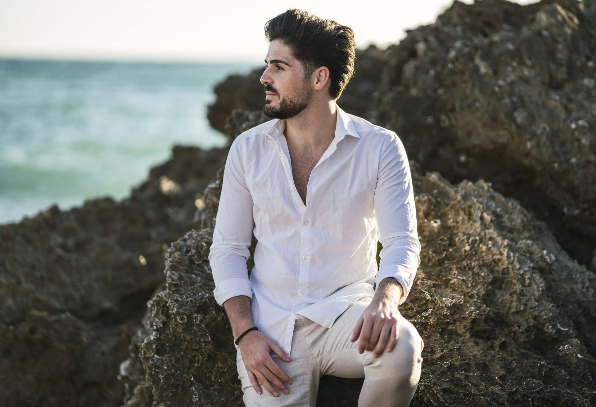 Man in a white button up top at the beach