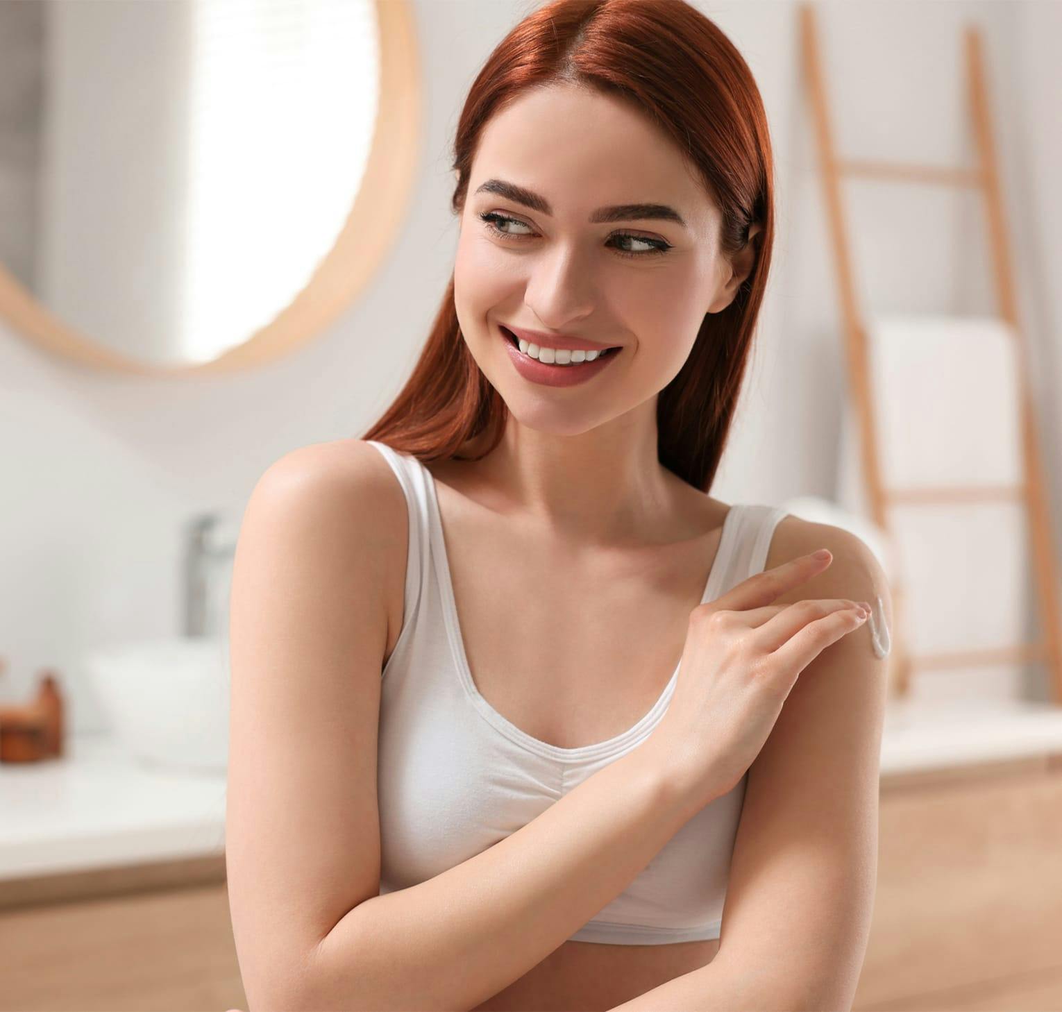 Woman in a white top with long red hair