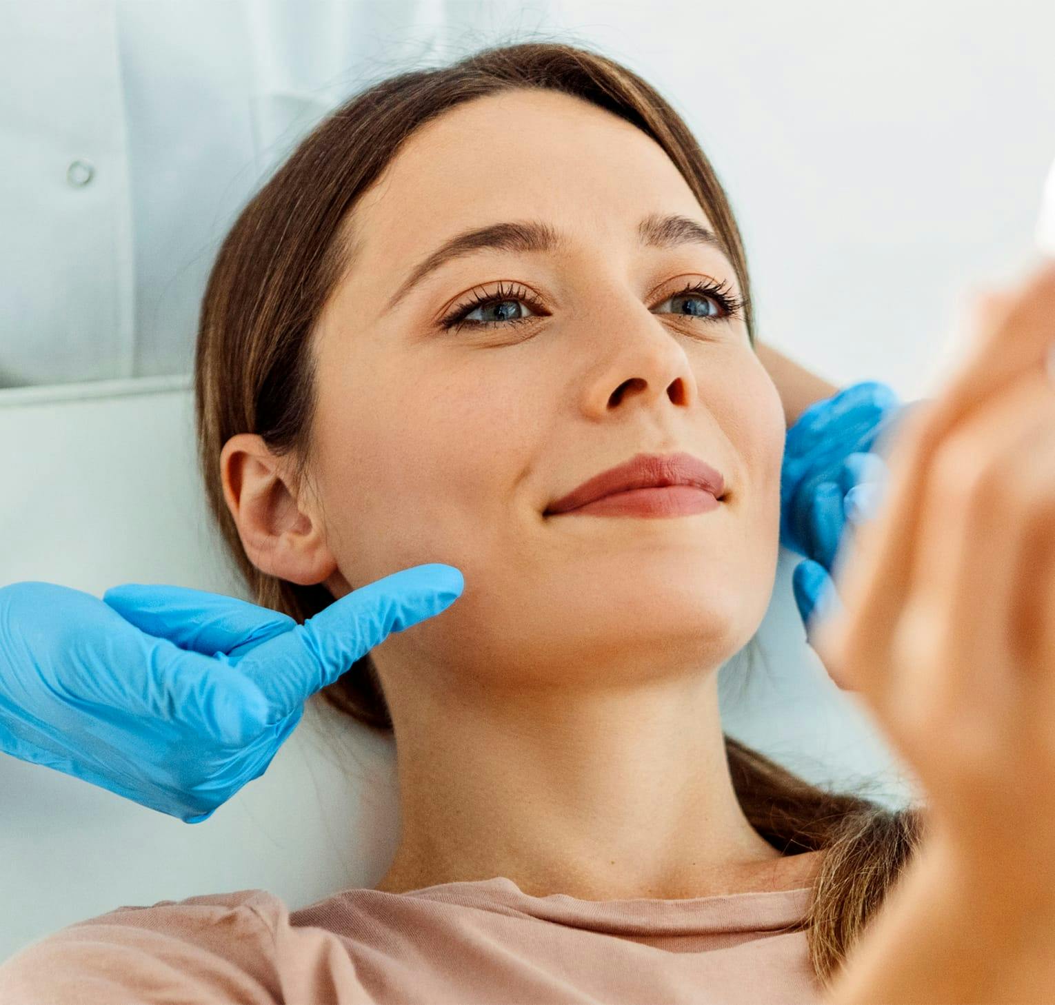 woman holding a hand mirror looking at face