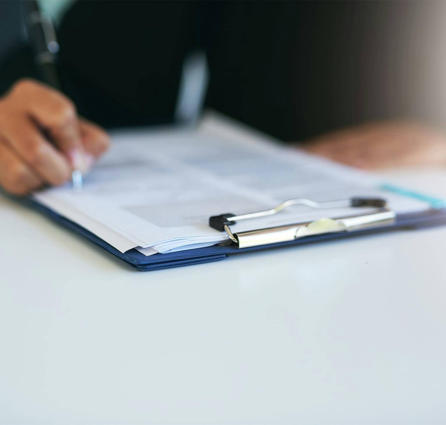 person writing on clipboard