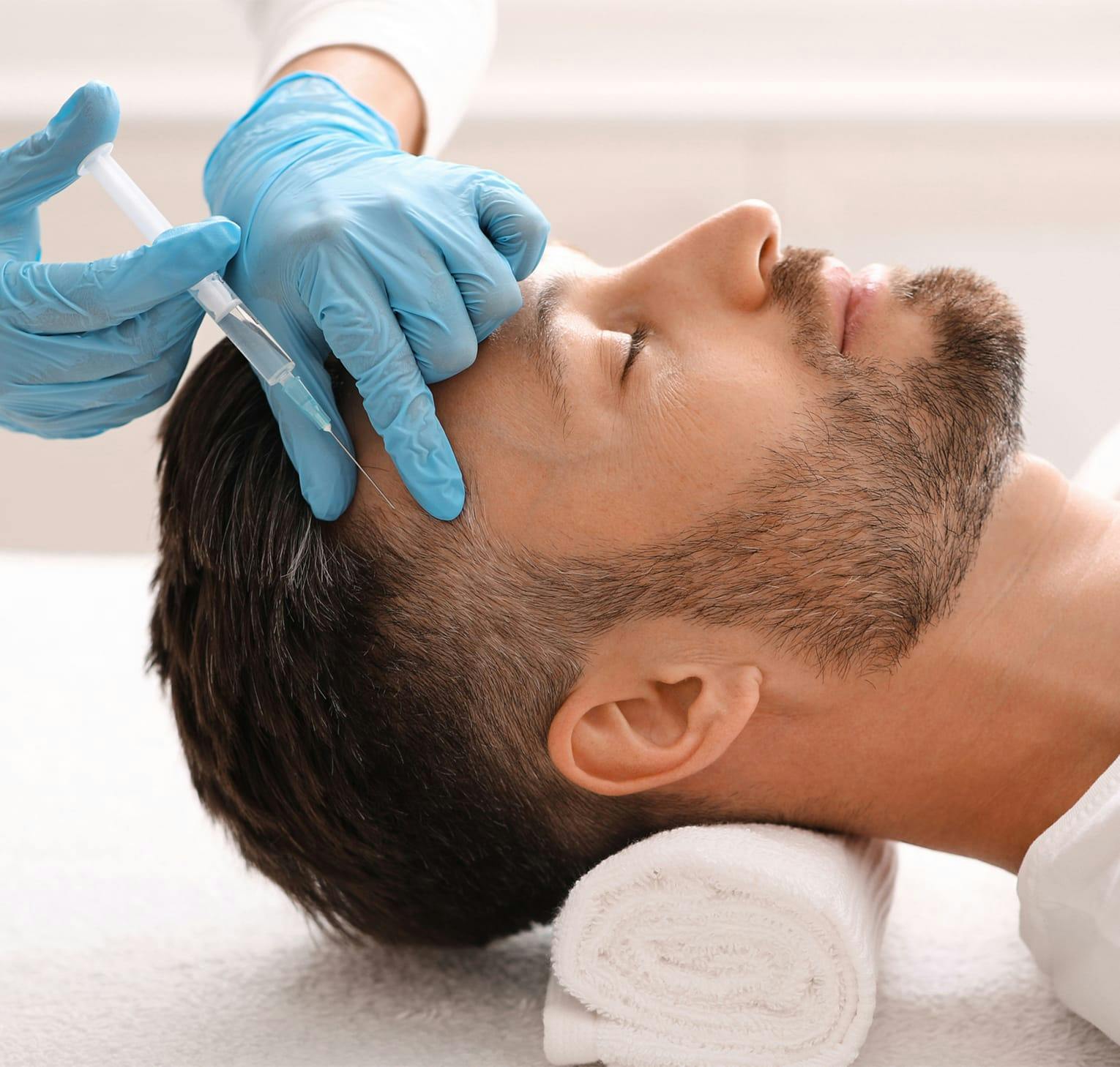 man getting an injection in his hairline