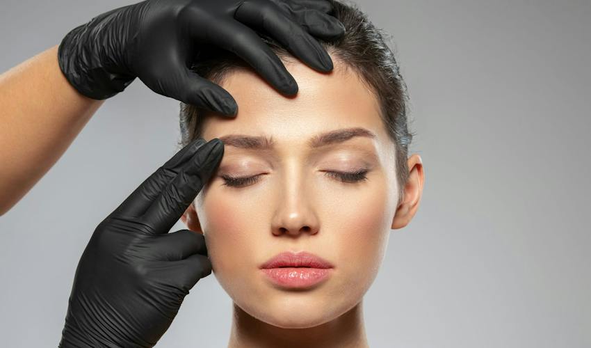 hands with gloves touching woman's face