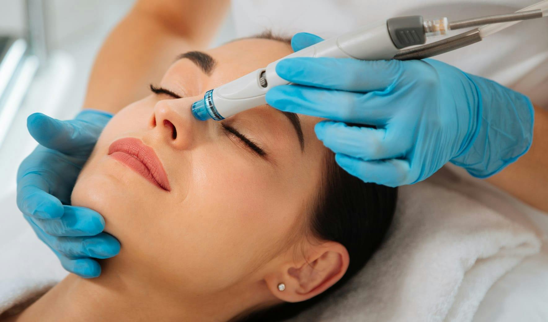 woman with a hydrafacial wand on her nose