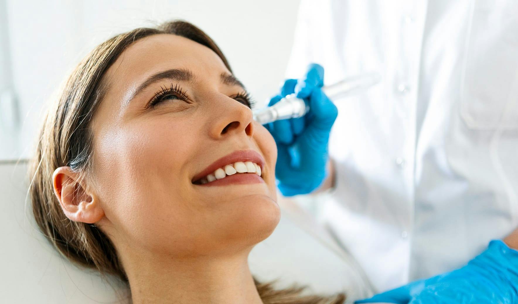 nurse putting a Microneedling pen on patients face