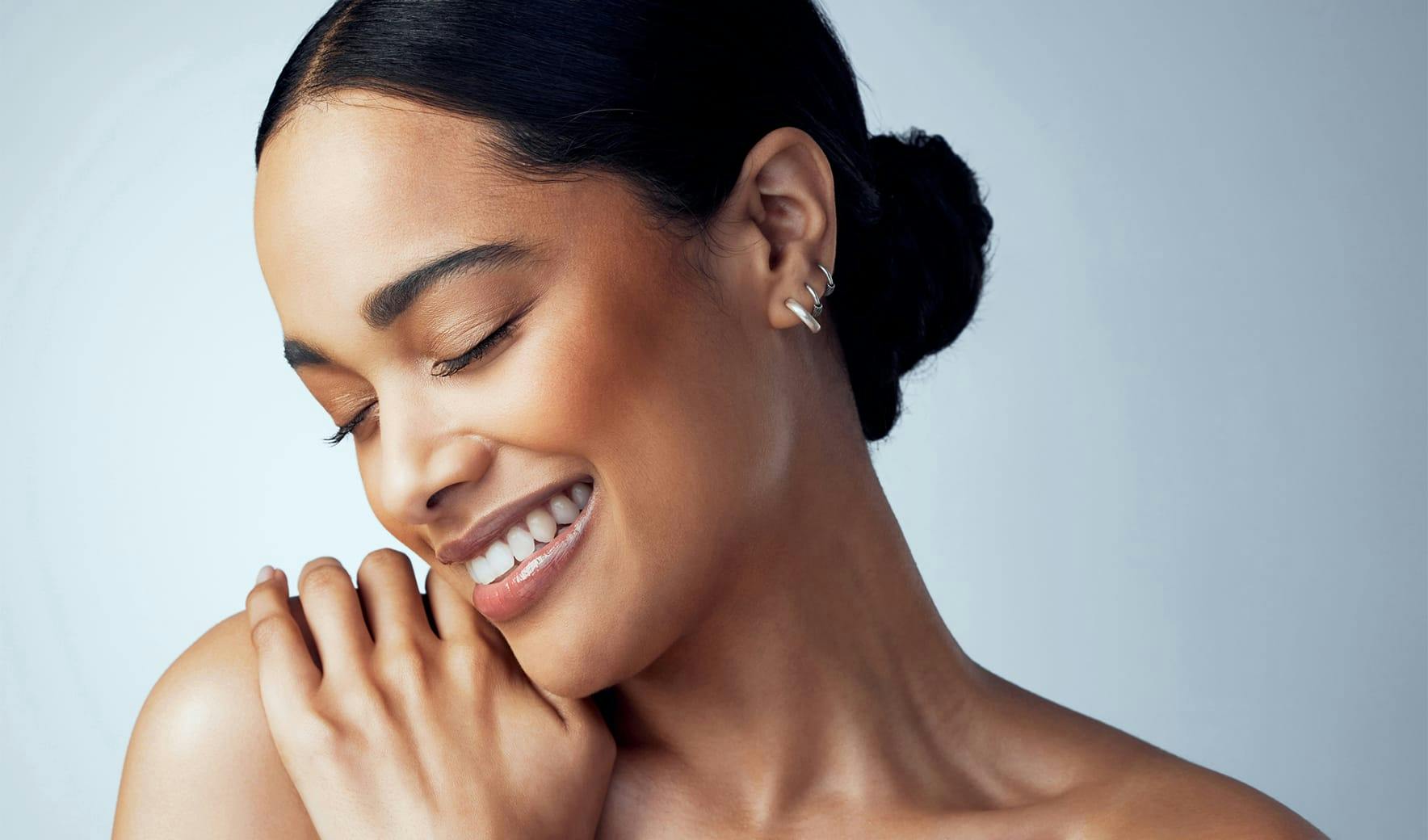 smiling woman touching her shoulder