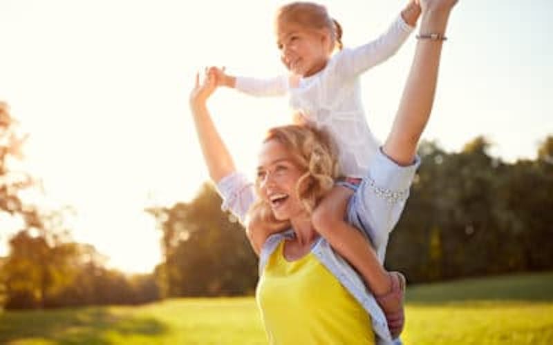 Mother with daughter sitting on her shoulders
