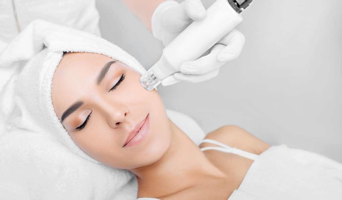 Woman receiving laser facial treatment.