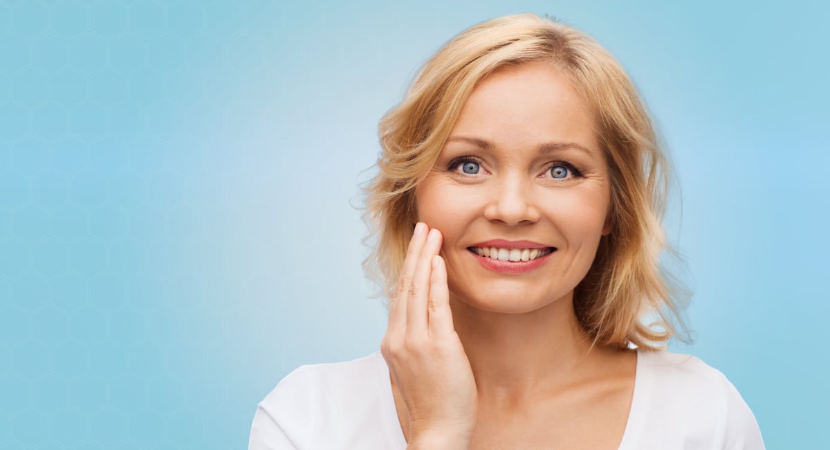 Smiling woman in white t-shirt touching her face