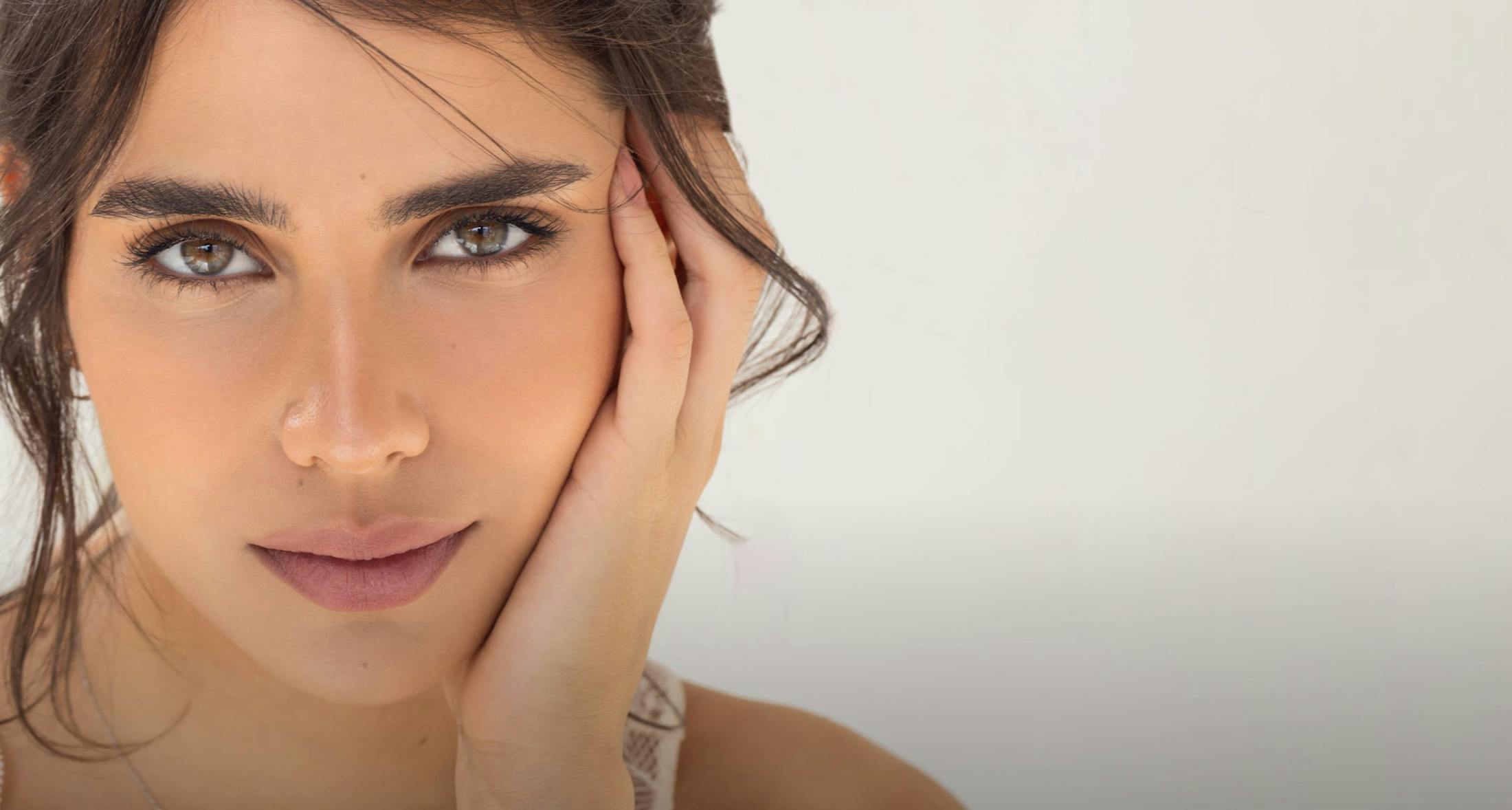 woman touching face with her hand