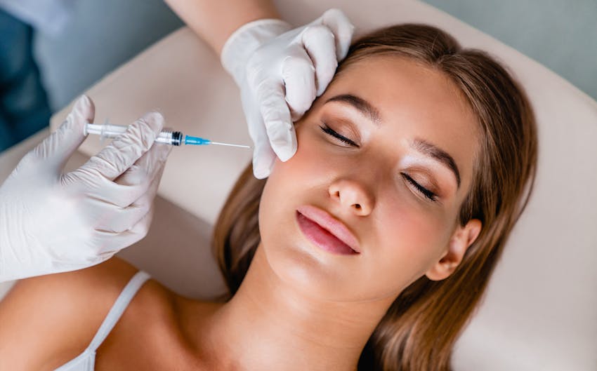 Woman laying down and receiving injectable treatment