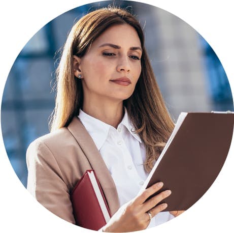 Woman in business clothes looking at paperwork on clip board