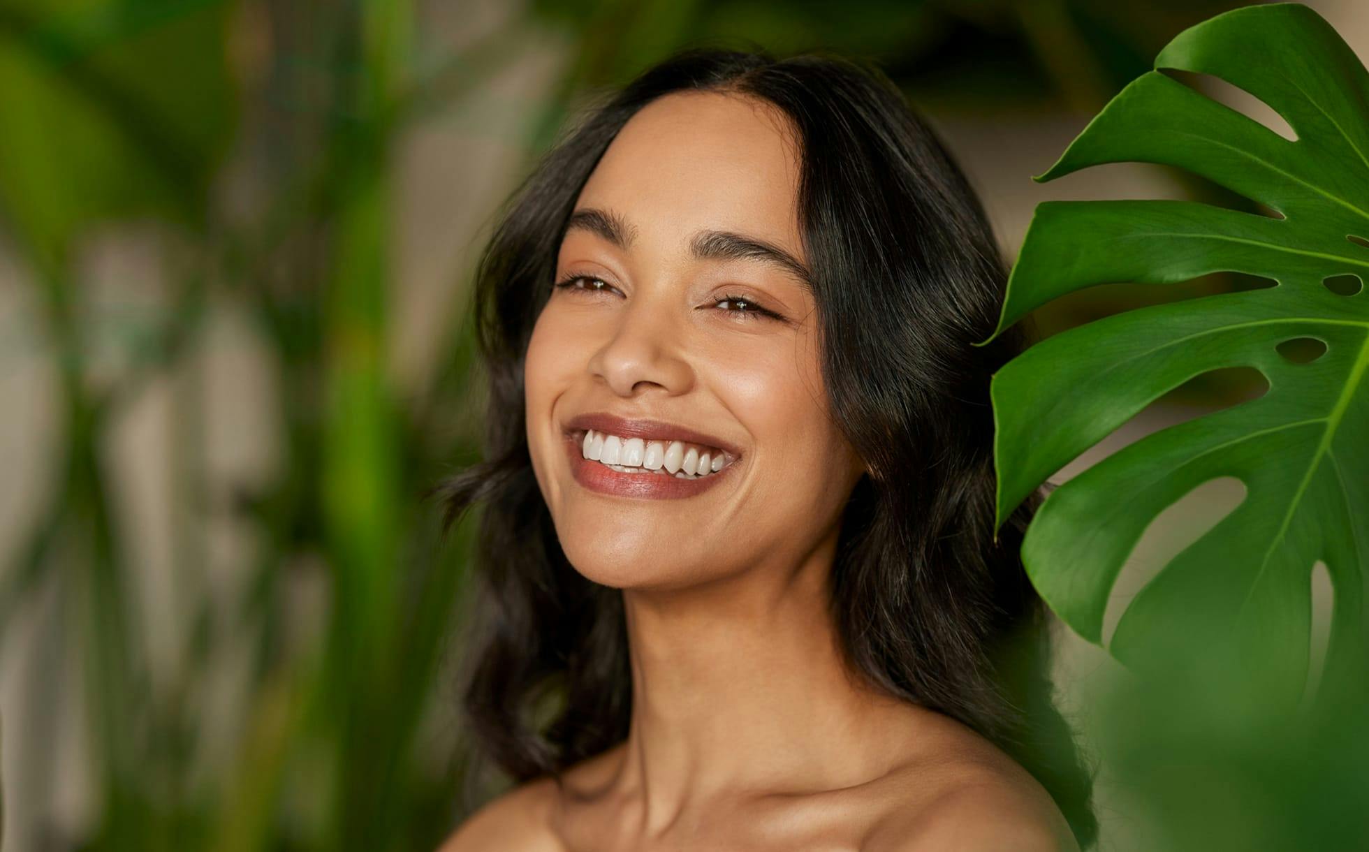 woman smiling next to leaves
