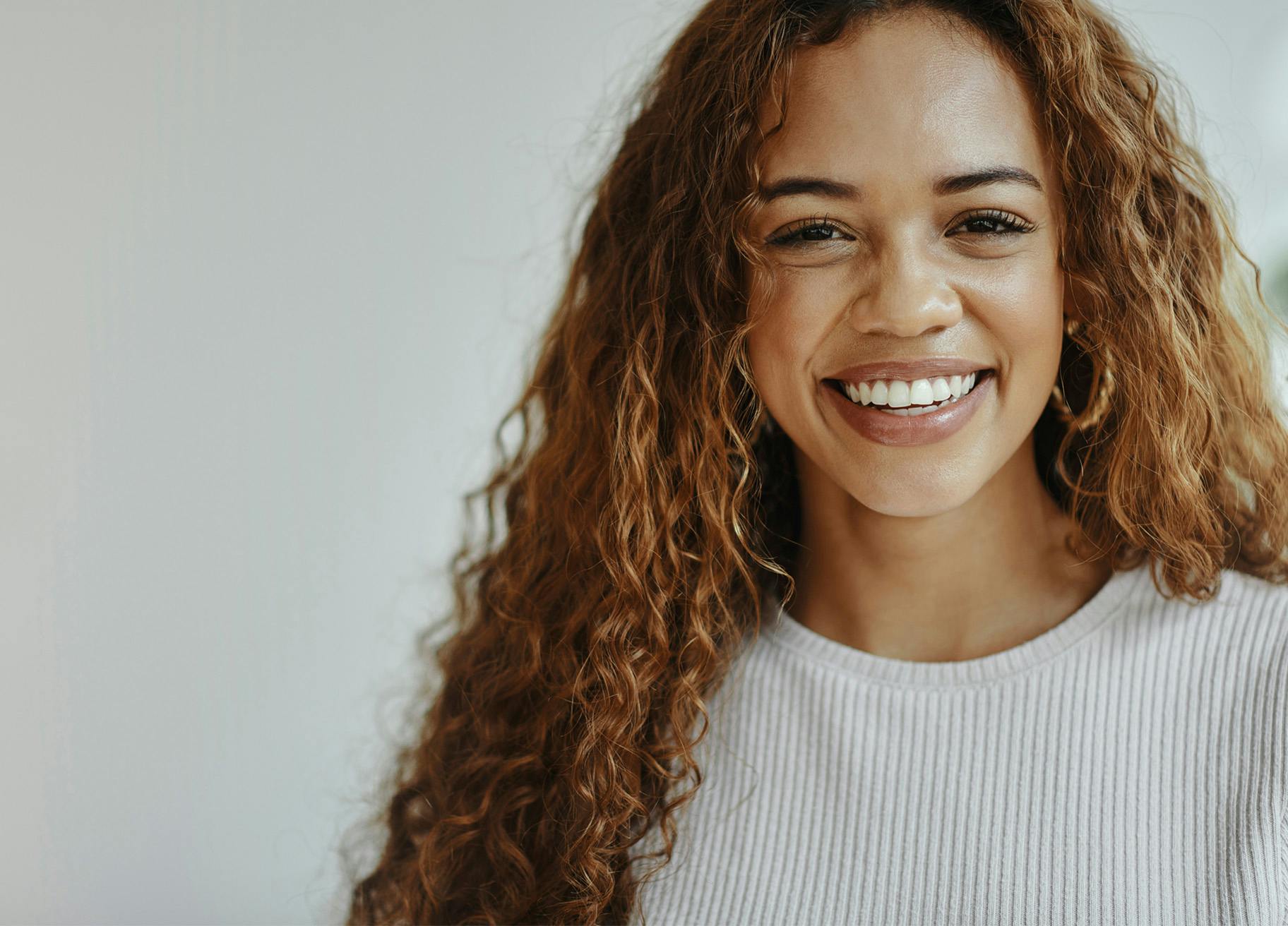 Woman with long curly hair smiling