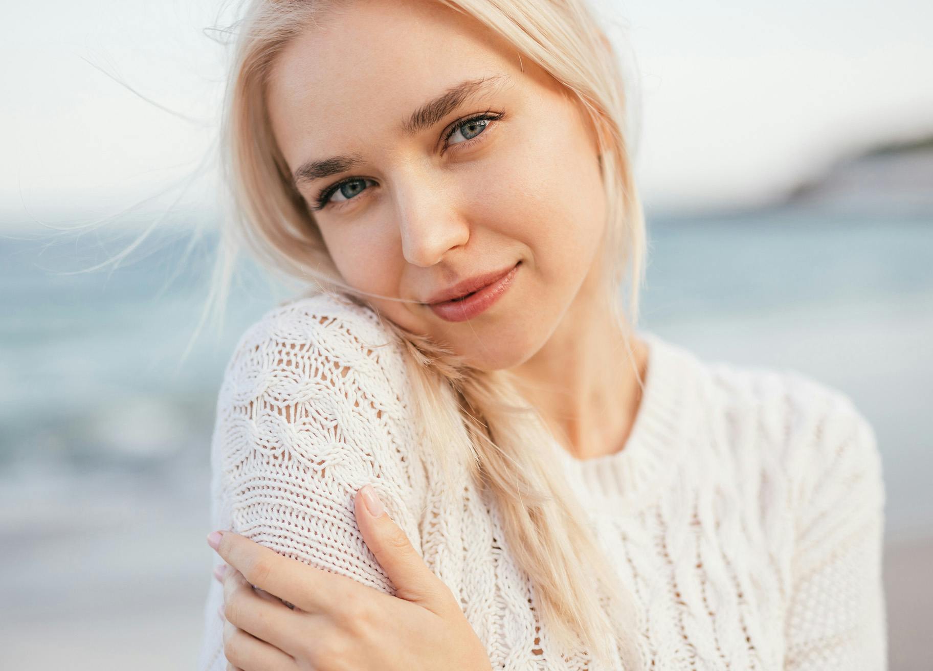 Woman with blonde hair wearing a white sweater