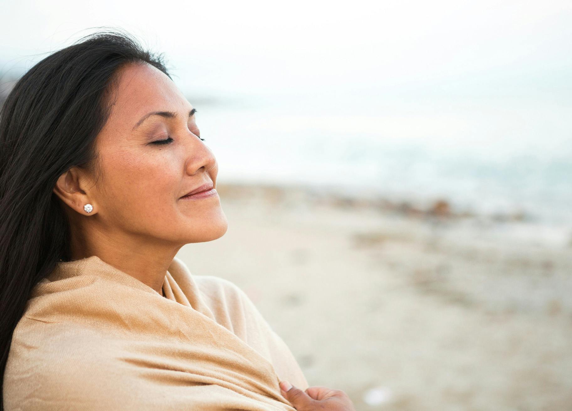Woman at the beach with her eyes closed