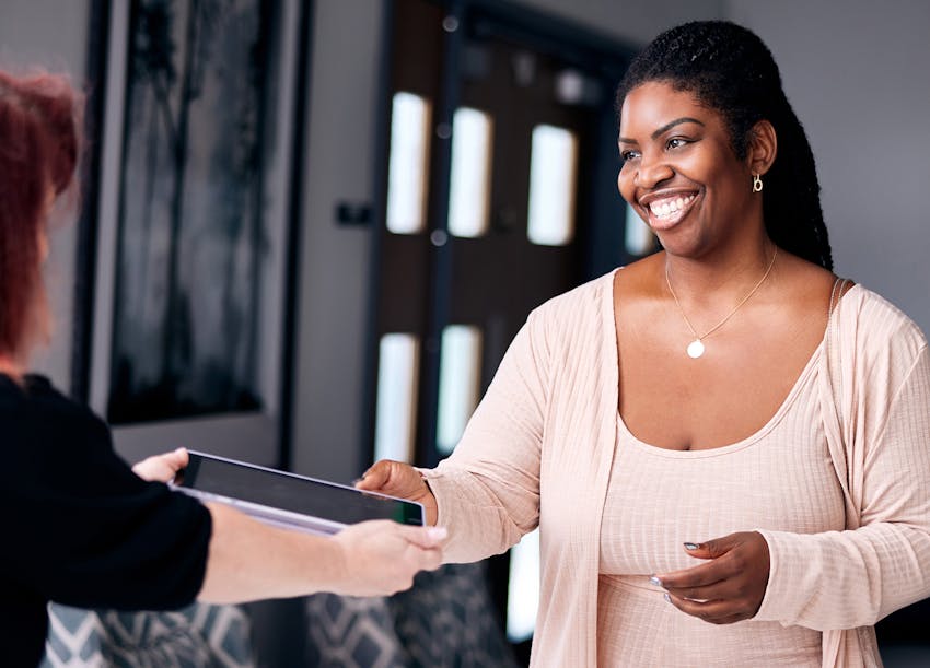 Staff giving patient an iPad to fill out information