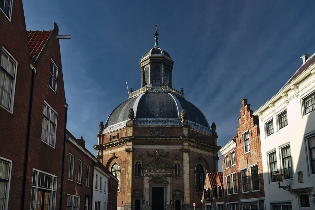 De Oostkerk met omringende huizen in de stad Middelburg
