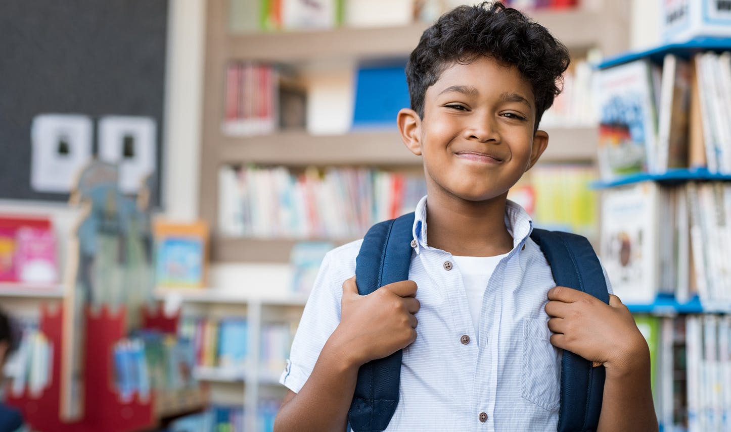 child wearing backpack in library
