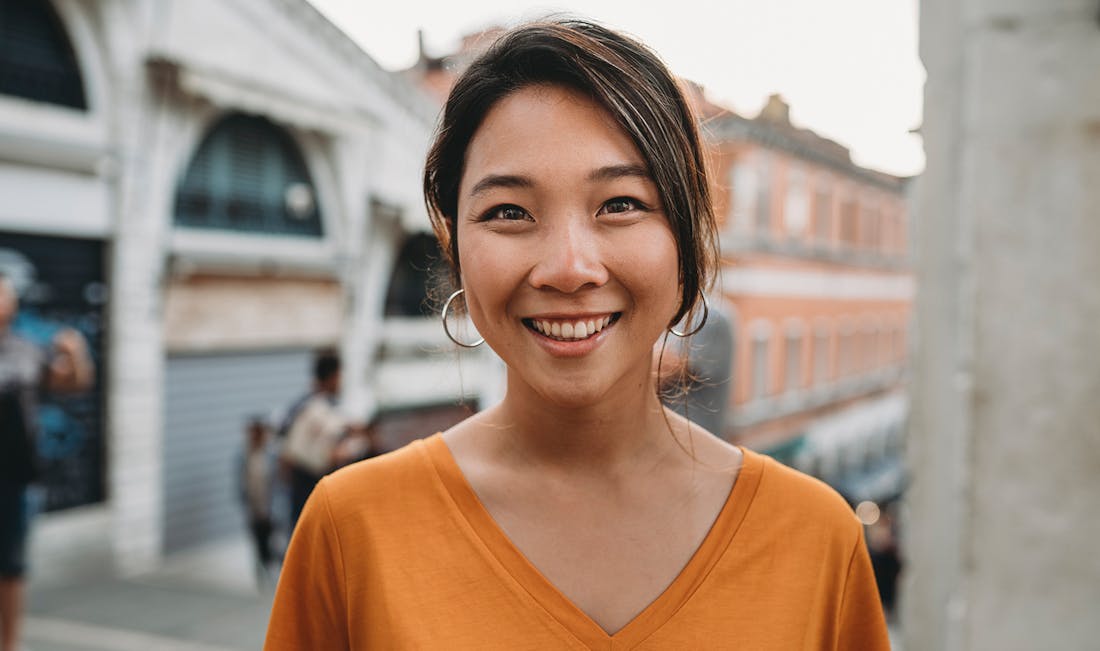 smiling in orange v-neck