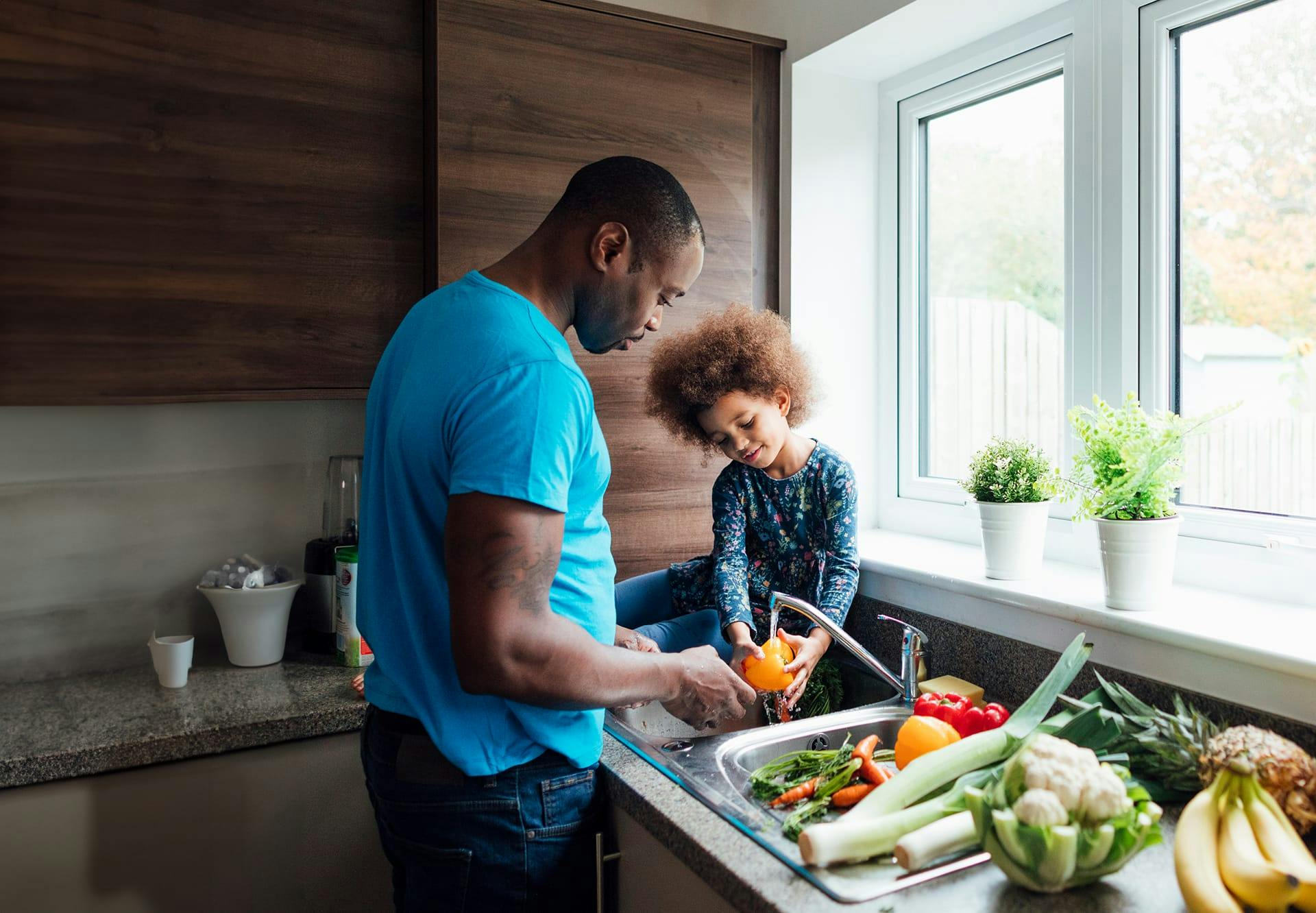 dad and daughter washing vegetables
