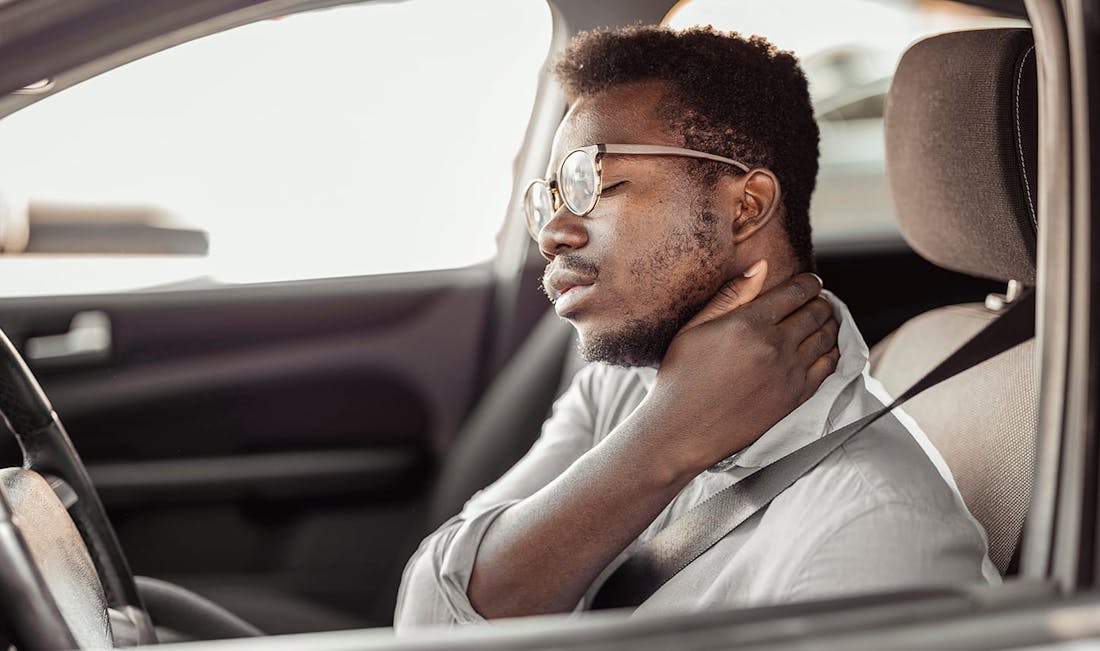 man holding neck in car