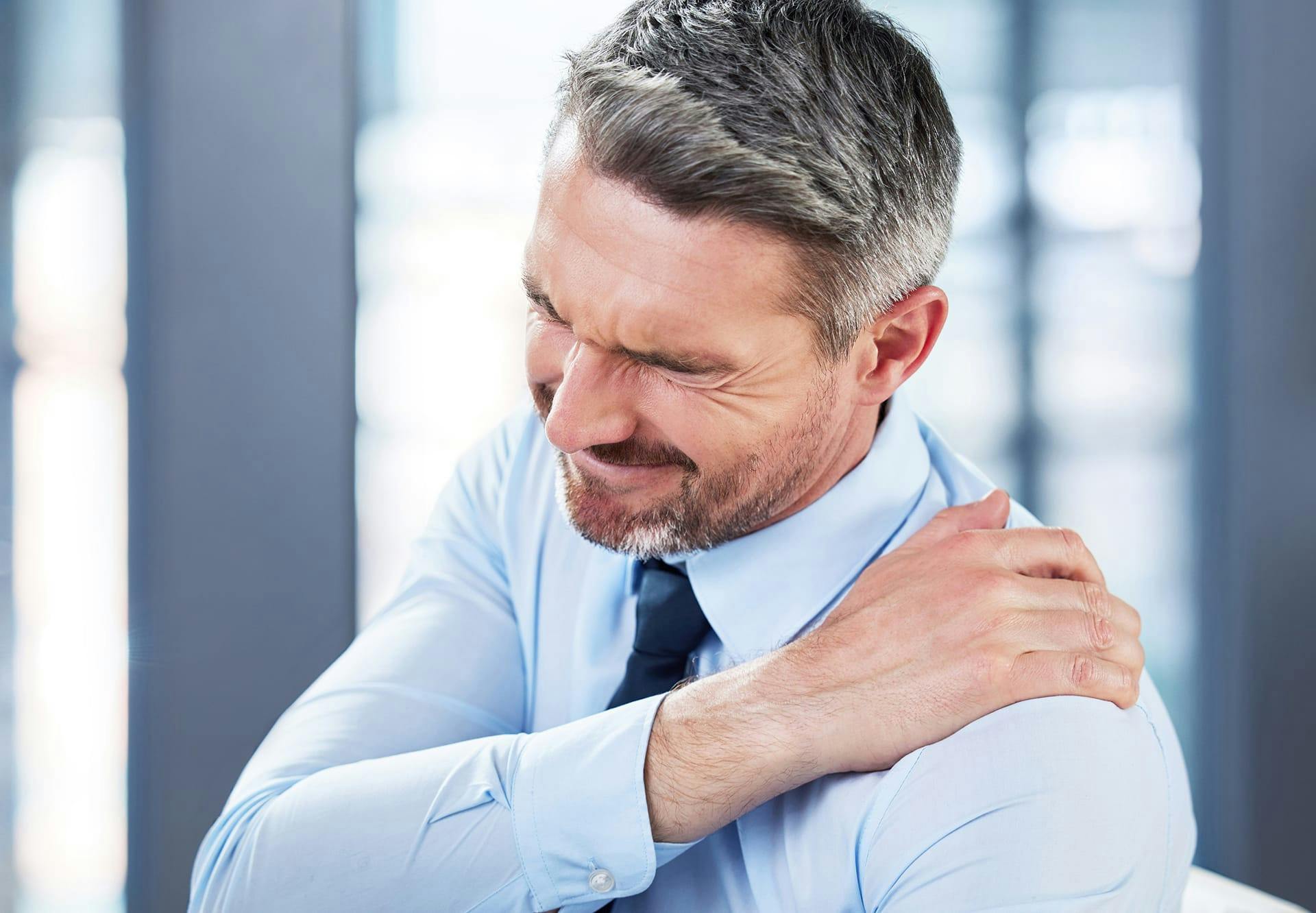 man holding his shoulder in pain