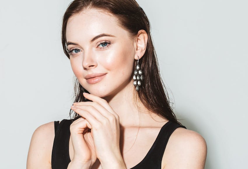 woman with hand in hand smiling at camera