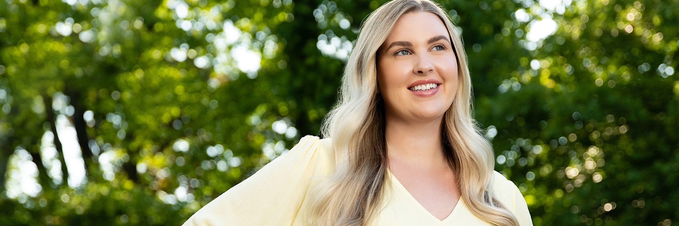 smiling woman with arms akimbo