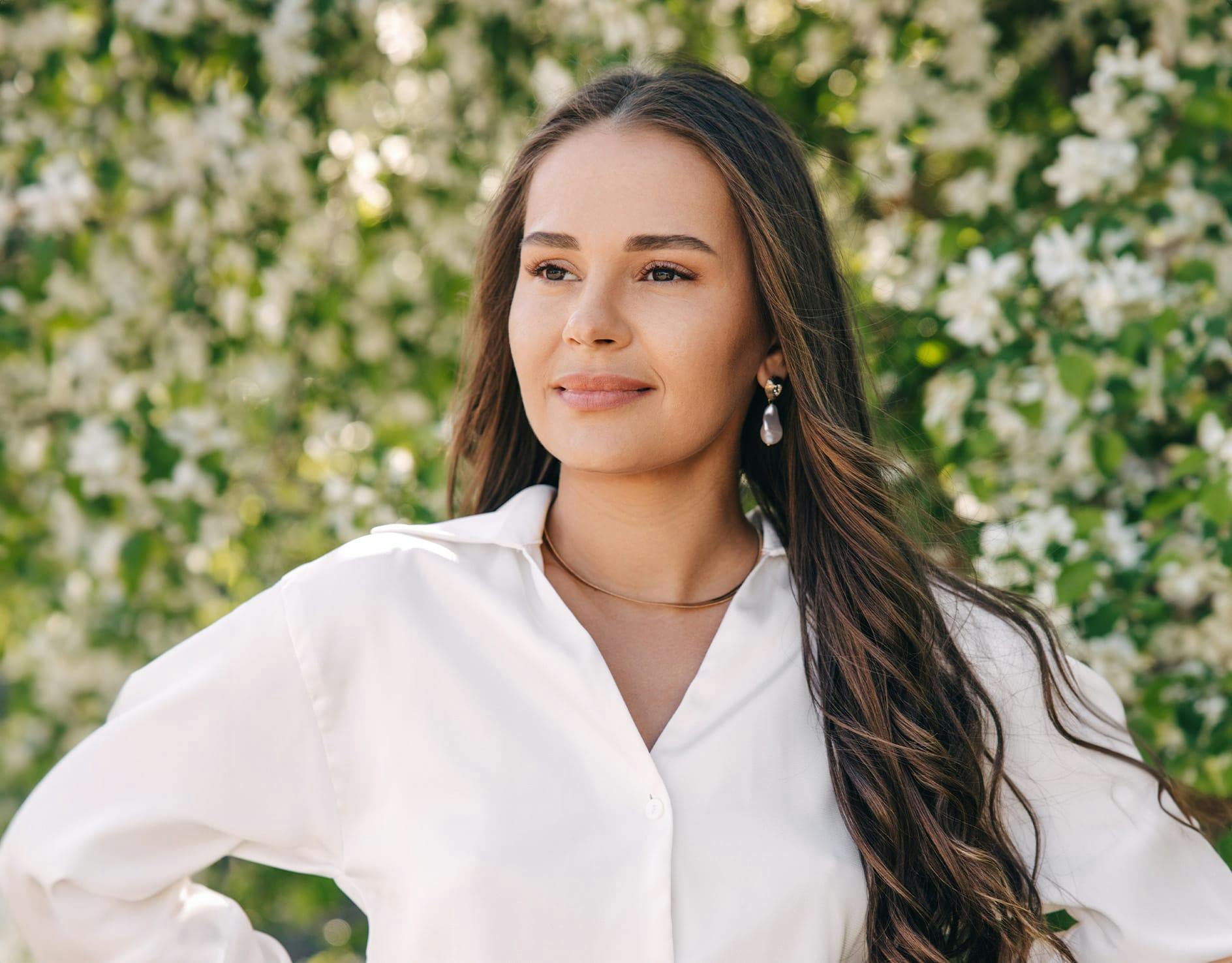 woman with long dark brown hair wearing a white button up shirt