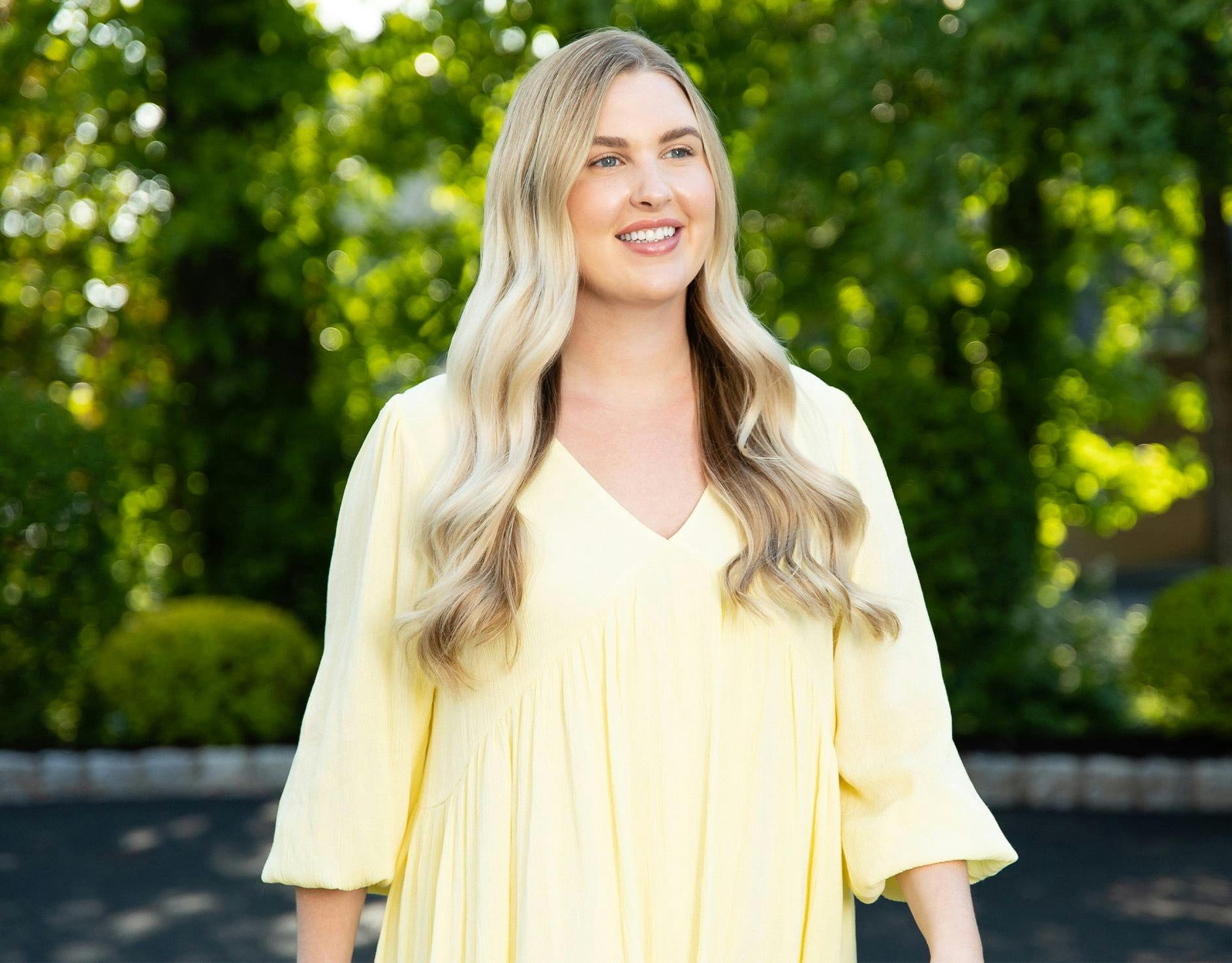 woman with long blone hair wearing a yellow top