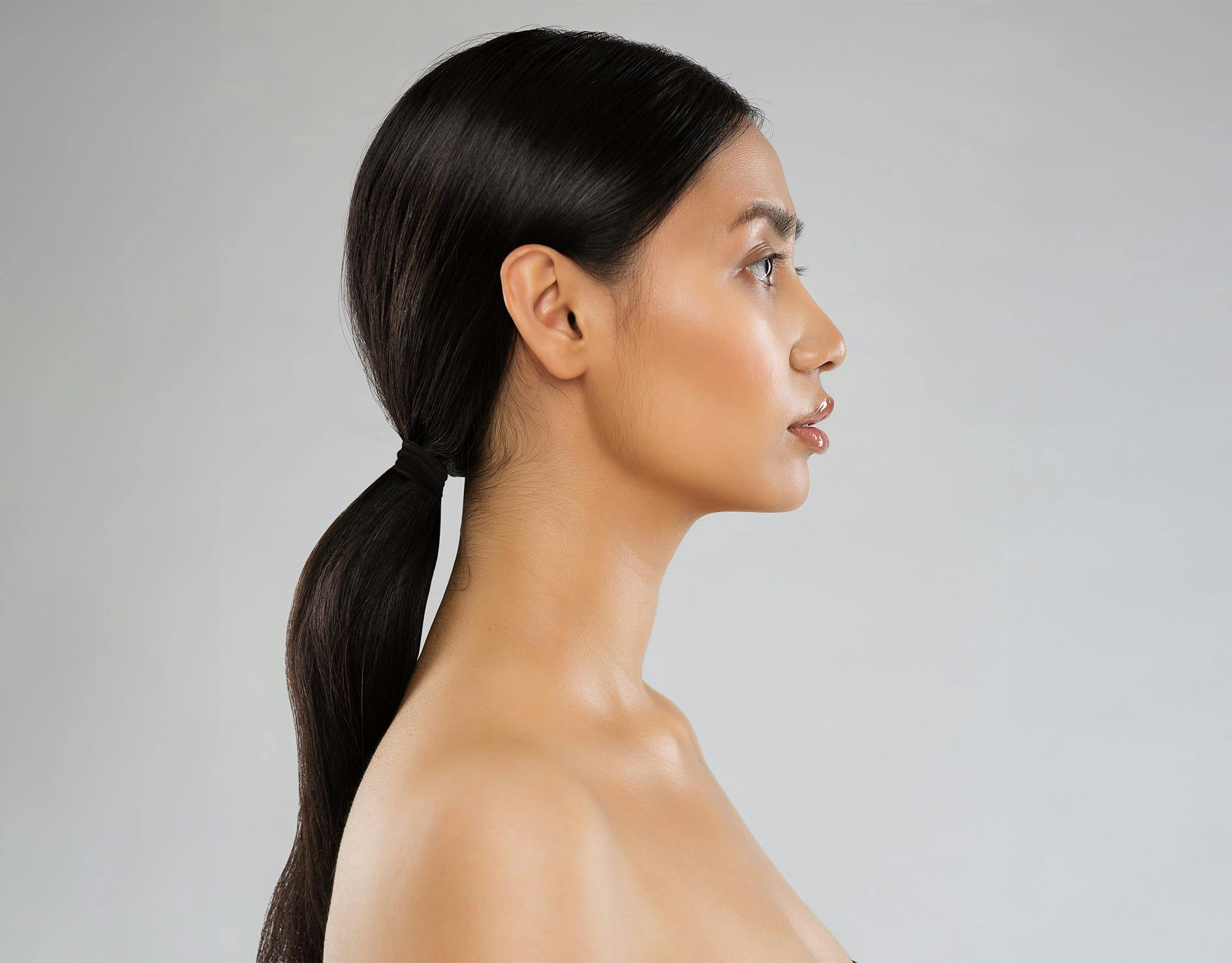 side profile of woman with long dark hair in a low ponytail