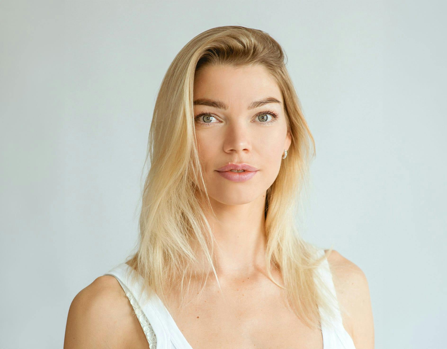 woman with eyes closed holding face