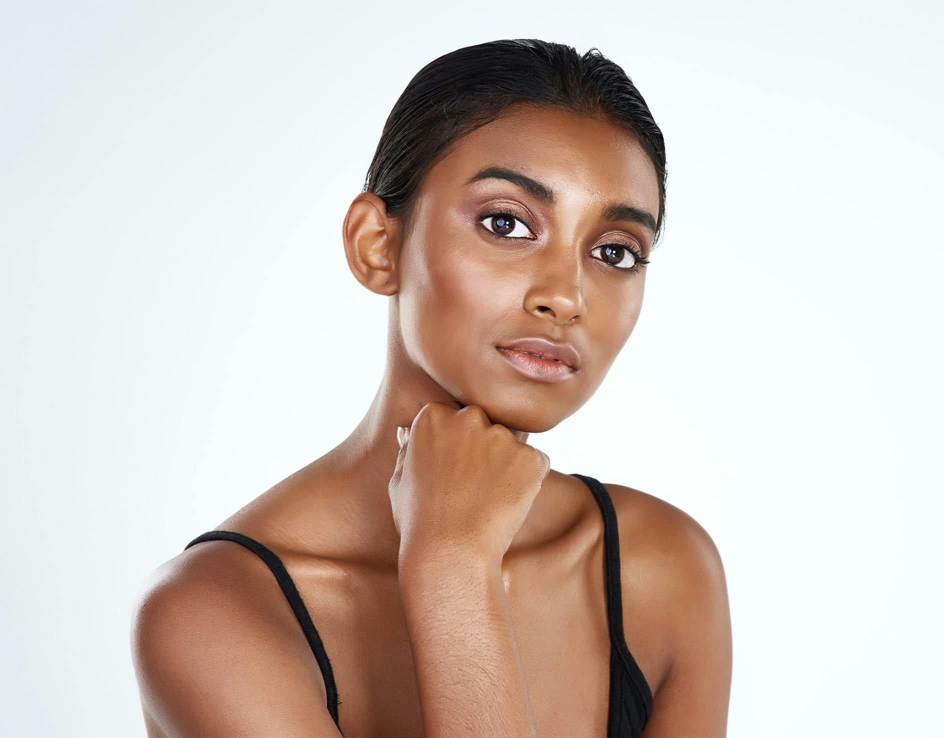 smiling woman with finger under chin