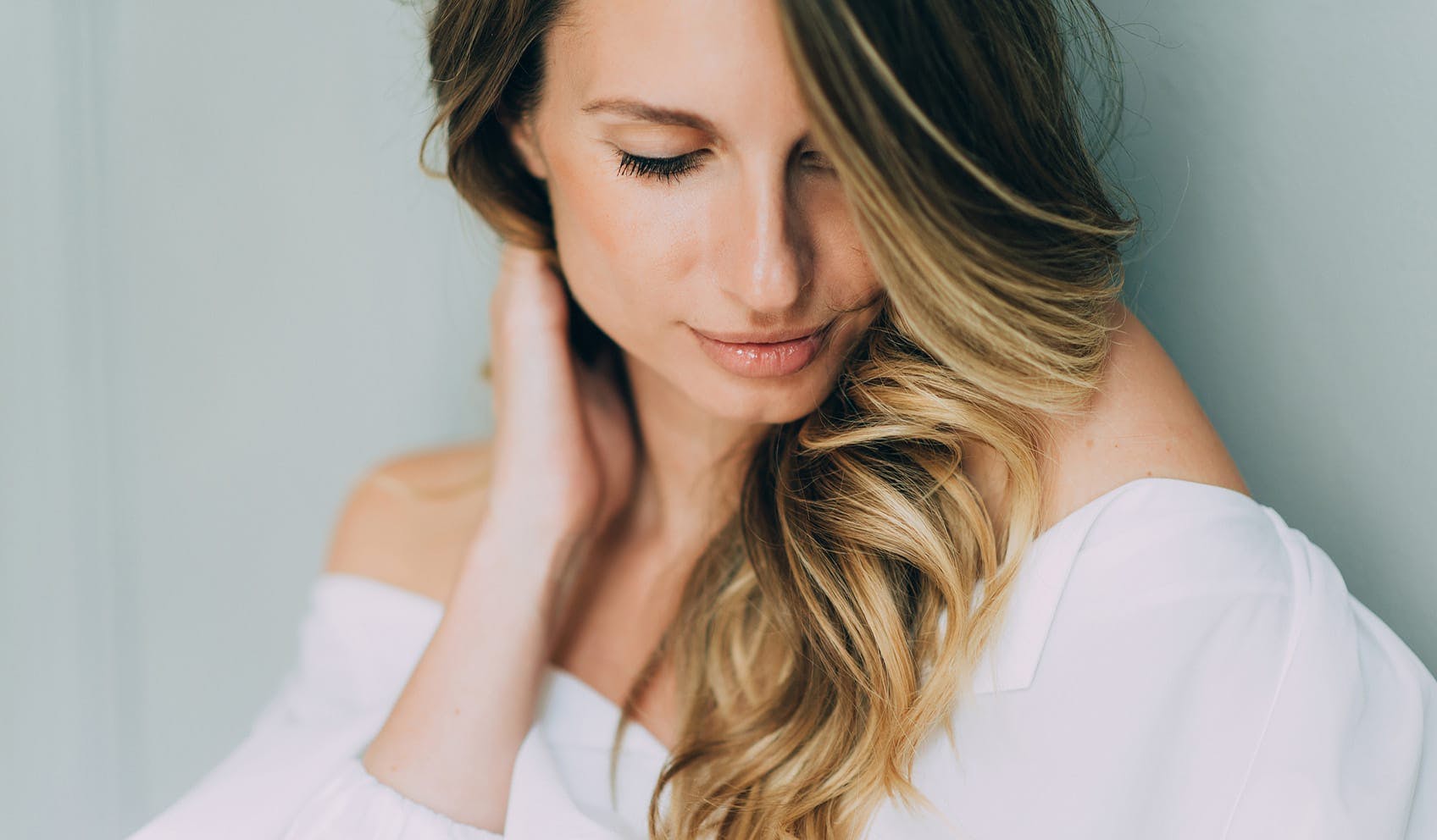 Beautiful woman holding hair and looking down