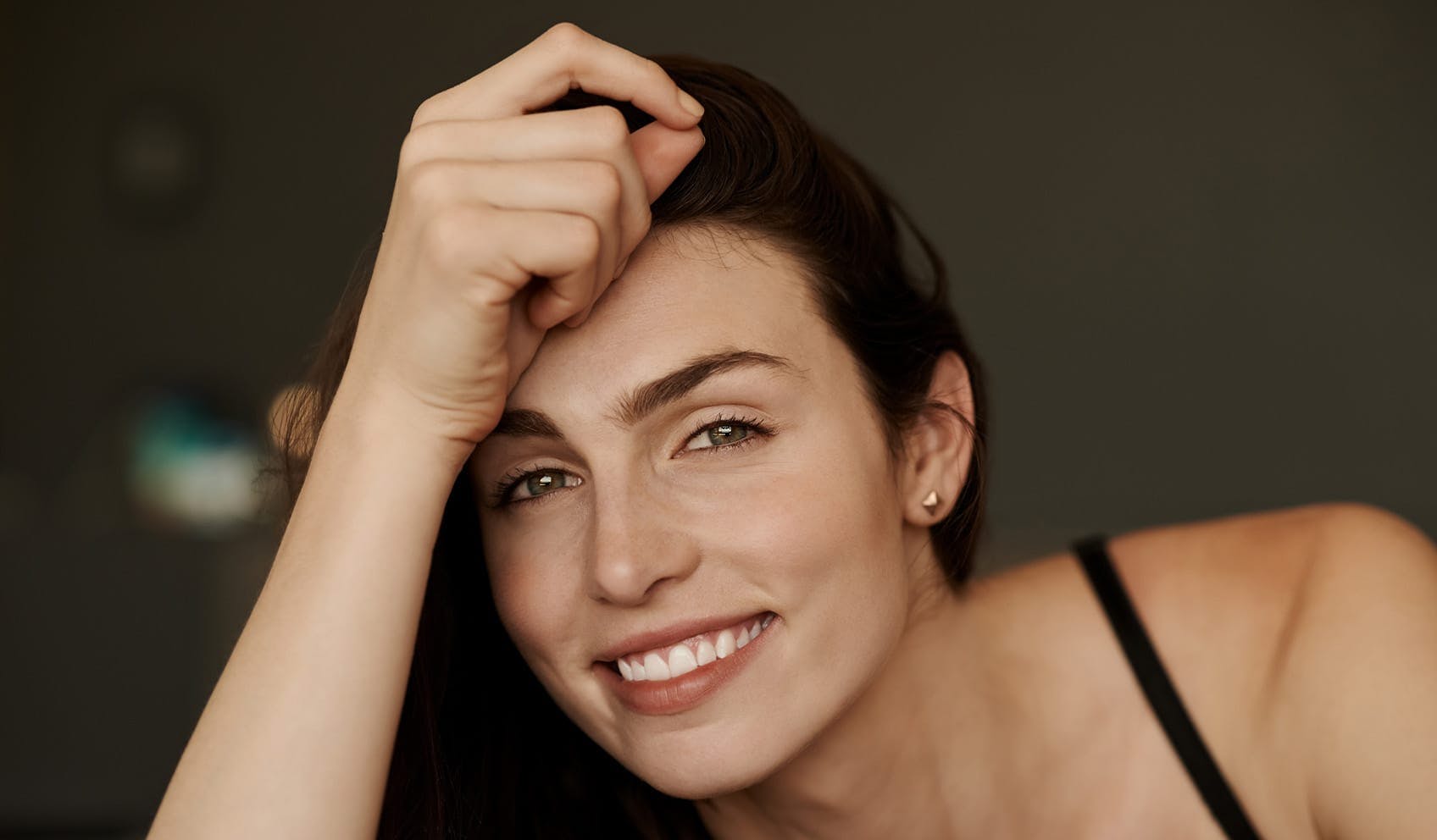 Woman smiling and holding head up