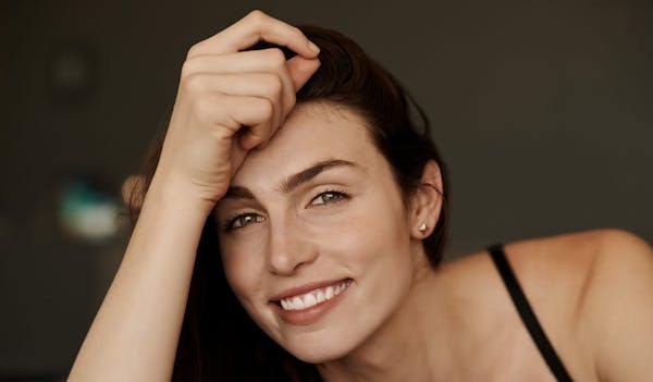 Woman smiling and holding head up